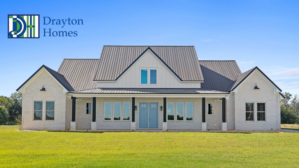 Modern custom white brick home with a dark metal roof and light blue front doors built by Drayton Homes
